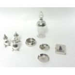 Three silver pepper pots, a silver mounted glass scent bottle and four Arabic pieces of silver,