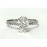 An 18ct white gold single stone ring, claw set with an oval cut stone, weighing approximately 1ct,