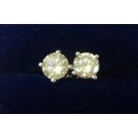 A pair of 14 K white gold and diamond stud earrings, claw set with brilliant cut stones of