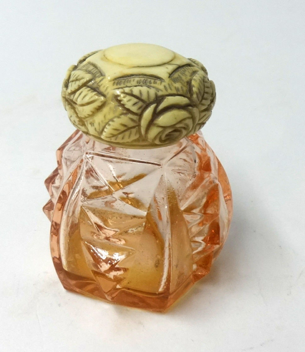 A glass scent bottle with carved ivory cover.
