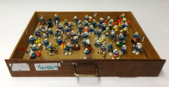 A collection of smurfs and a small display cabinet and a smurfs apron, (approximately 54).