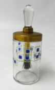 A decorative glass bottle, the lid inset with a brush.