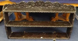 A dark carved oak set of hanging wall shelves, 19th / 20th century, width 131cm.
