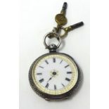 Ladies silver and open face fob watch with Swiss movement, key wound and enamel and gilt dial