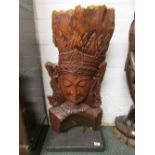 Head and shoulders figure of female Buddhistic deity carved from wooden trunk, on a rectangular base