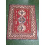 A modern Oriental-style rug with three medallions on a brick red ground and eight margins (145cm x