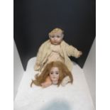 A composition doll with damaged porcelain head numbered 2048, a detached porcelain doll's head