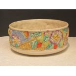 Clarice Cliff fruit bowl, cream ground moulded with fruit and flowers, Newport Pottery Co mark and