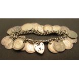 A silver bracelet with heart-shaped lock fixed with approximately nineteen silver threepenny pieces,