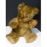 A mid 20th century plush teddy bear with articulated arms and legs (height seated 30cm)