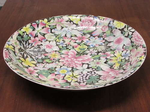 Large Chinese porcelain dish enamelled in the famille rose palette against a black ground with