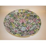 Large Chinese porcelain dish enamelled in the famille rose palette against a black ground with