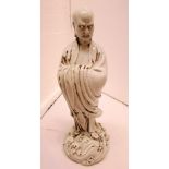 Blanc de chine porcelain figure of robed man standing on mound of stylized waves, height 27.5cm