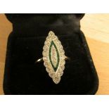 Diamond and emerald ring in a marquise setting (25mm x 10mm), perimeter of eighteen diamonds (