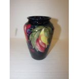 Initialled Moorcroft baluster vase decorated with grapes and leaves on blue ground with original