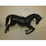 A leather clad model of a cantering racehorse with saddle and reins (50cm x 33cm)