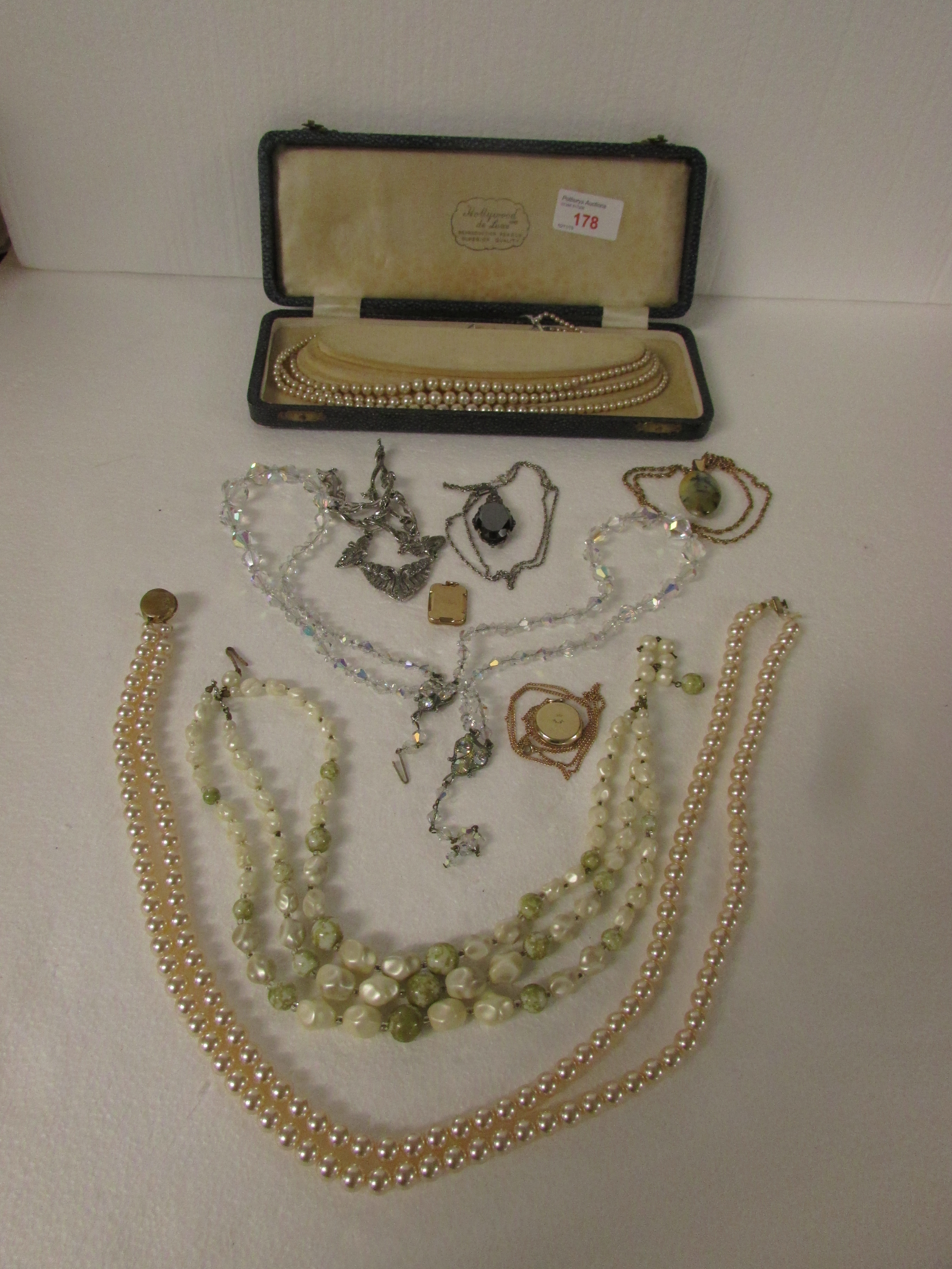 A box of assorted dress jewellery consisting of marcasite necklace, 9ct gold engraved oblong locket,