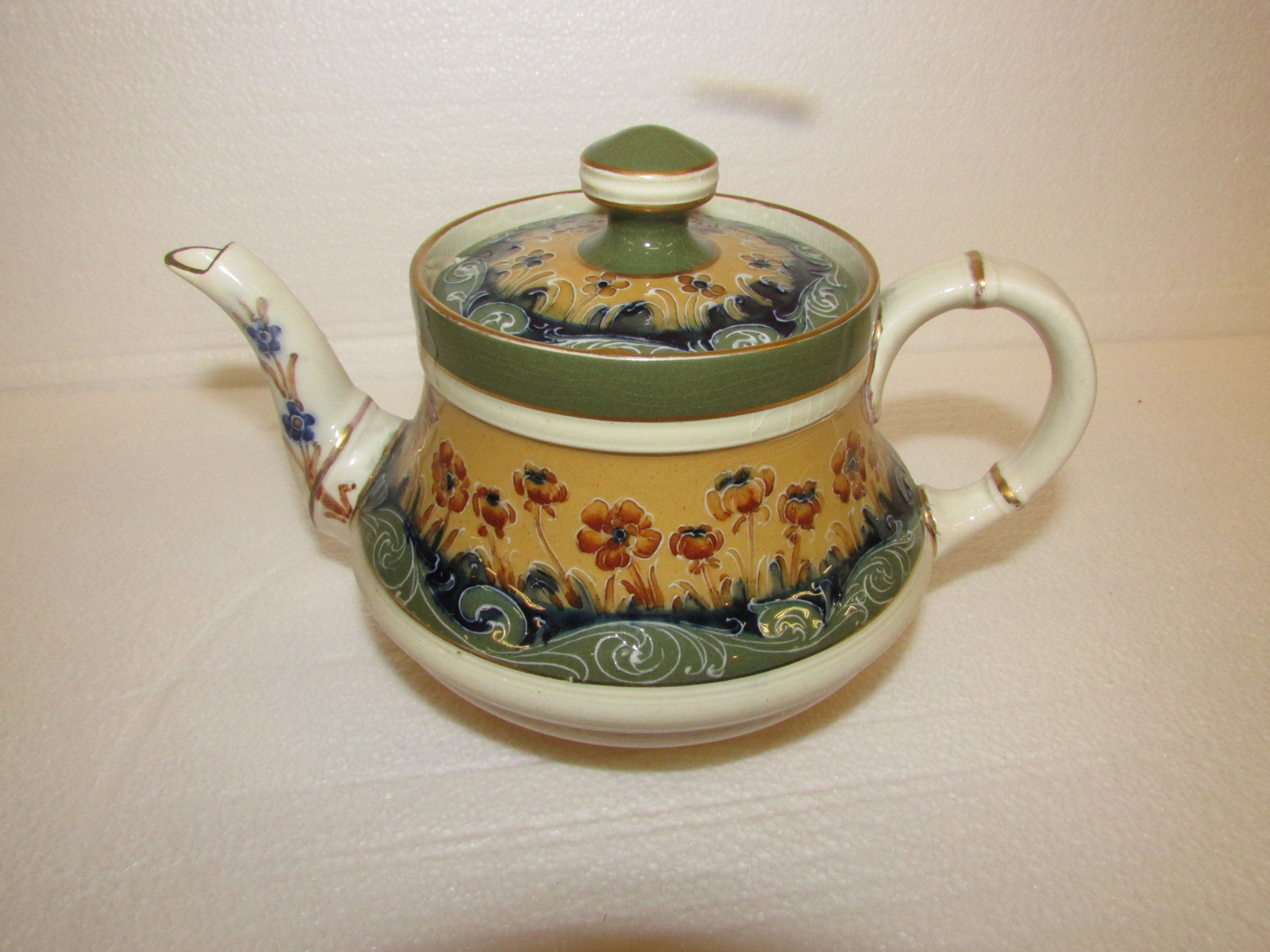 Transitional Macintyre teapot reg no. 401753 decorated with cream and green bands of floral and