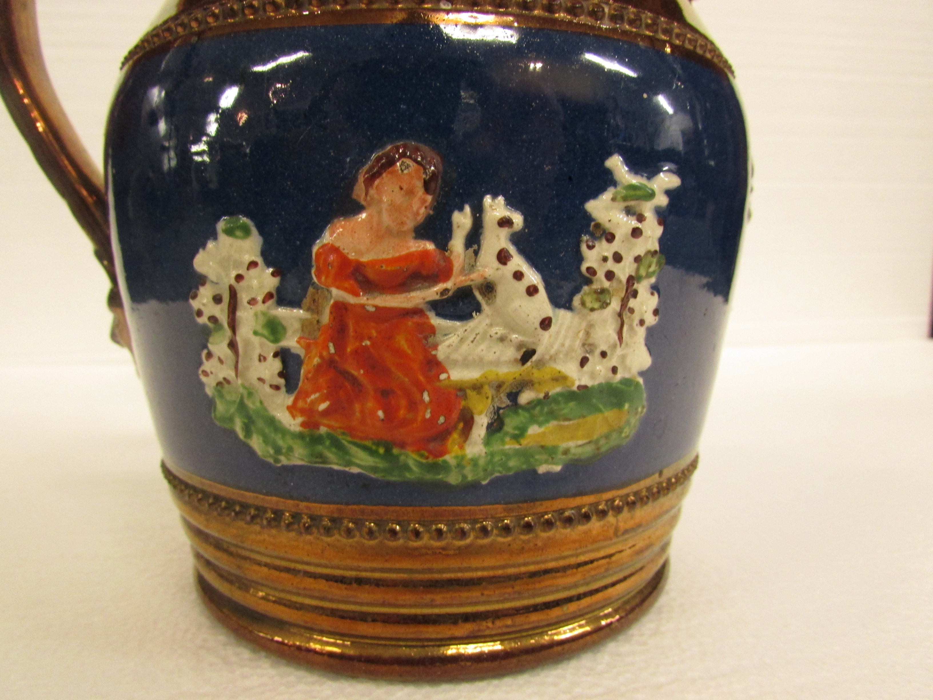 A 19th century copper lustre jug with a band of blue glaze with seated girl and dog in relief - Image 4 of 4