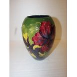 An initialled ovoid Moorcroft vase decorated with hibiscus on green ground, W.A.Moorcroft, 18cm