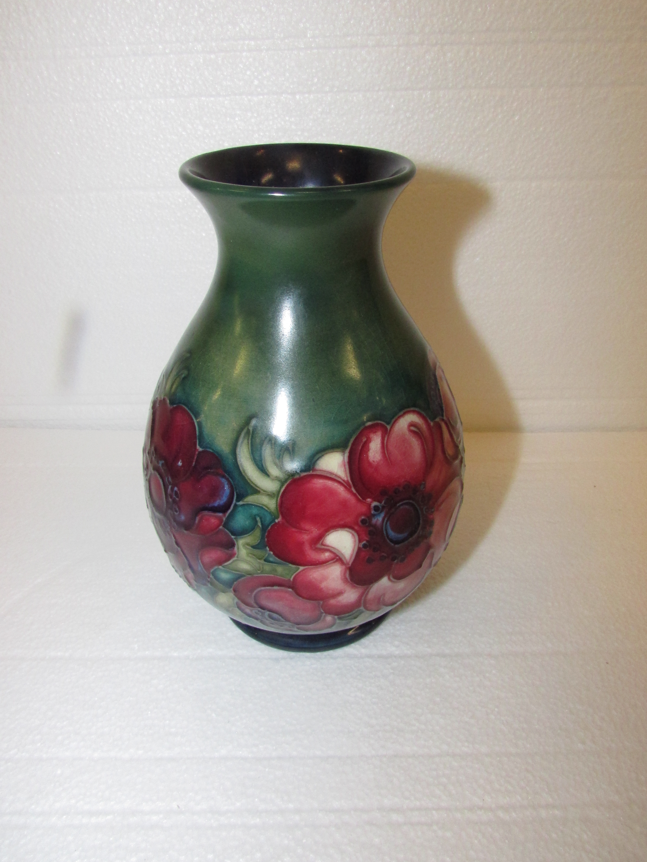 An initialled pinch necked ovoid Moorcroft vase decorated with anemone on green ground, W.A.