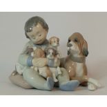 Lladro figure Boy seated with dog and puppies, length 13cm