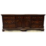 Georgian oak lancashire Dresser base, 8 drawers around central pair doors, canted corners with