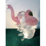 A Murano glass elephant, the animal seated with rearing mottled cranberry trunk and ears - with