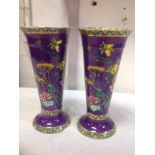 A pair of Maling trumpet vases, with three bright flower and leaf bands to tapering bodies,