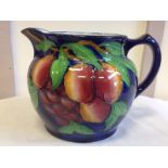 A Maling plum & orchard pattern jug of bulbous form, decorated with bright polychrome tube-lined