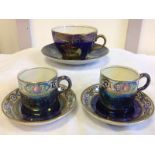 A Maling galleon pattern blue lustre and gilded cup & saucer; and a pair of Maling plum-and-