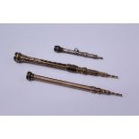 Two Victorian gold-coloured metal propelling pencils and a white metal propelling pencil (3)
