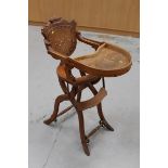 Victorian children's oak high chair with pierced back panel and label to rear 'Patent Carriage