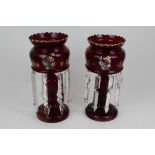 Pair of Victorian ruby glass lustres with painted floral decoration and prismatic drops,