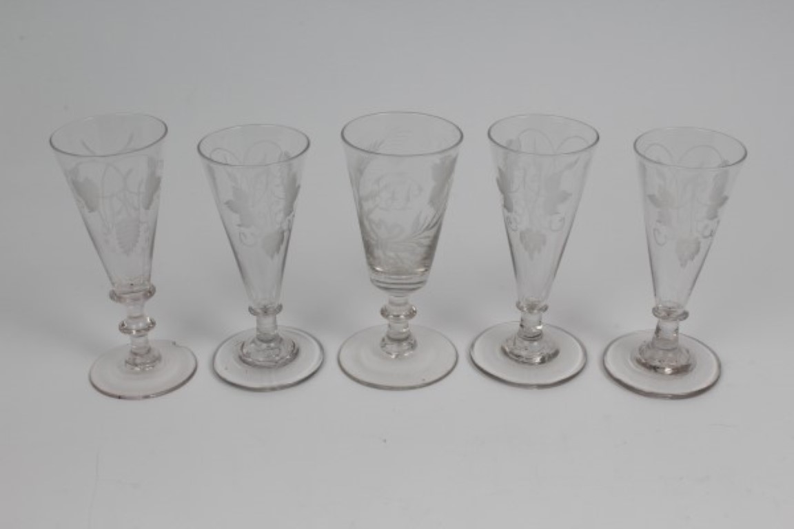 Five Georgian ale flutes with engraved hop decoration, all on splayed foot,