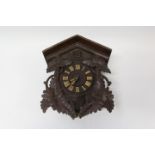 Black Forest-style wall mounted cuckoo clock with carved foliate decorated wooden case,