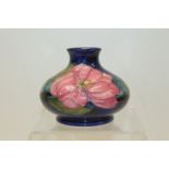 Moorcroft pottery vase decorated in the Clematis pattern on blue ground,