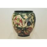 Moorcroft pottery vase decorated in a floral pattern on graduated cream ground,