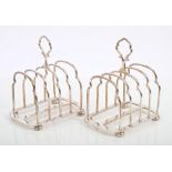 Pair George silver four-division toast racks with central carrying handles,