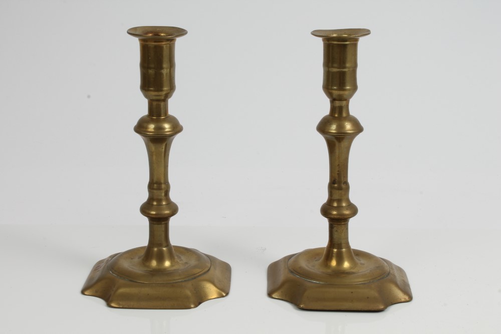 Pair of 18th century brass candlesticks, each with knopped column raised on canted square base,