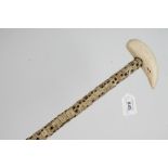 Shark vertibrae walking stick with whale tooth handle and brass ferrule,