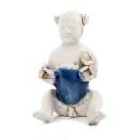 Small Chinese porcelain funerary figure modelled as a semi-naked seated boy holding auspicious