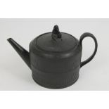 Early 19th century black basalt teapot and cover of squat cylindrical form,