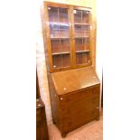 A 30" 1930's oak bureau bookcase with leaded glass doors, set over three long graduated drawers, set