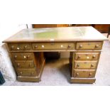 A 4' 4" early 20th Century stained oak double pedestal desk with tooled green leather inset top,