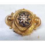 A Victorian fire gilt gold mourning brooch, with seed pearl set star motif and glass panel to