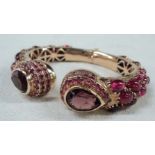 A marked 585 ornate clasp bracelet set with cabochon and other rubies with teardrop amethyst set