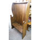 A 3' 3" elm and mixed wood curved wing back settle, with shaped sides and a solid seat with open