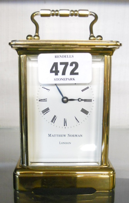 A brass and bevelled glazed cased carriage clock, with Roman numerals and white dial marked Mathew