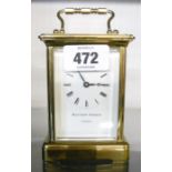 A brass and bevelled glazed cased carriage clock, with Roman numerals and white dial marked Mathew